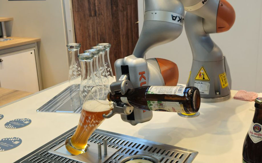 Roboterarm gießt Weißbier in ein passendes Glas